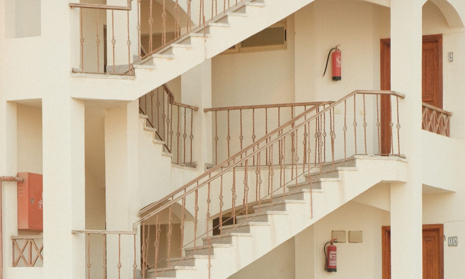 pexels-panditwiguna-34939776 Interior staircases and corridors in a multi-storey staff accommodation building with visible fire extinguishers.
