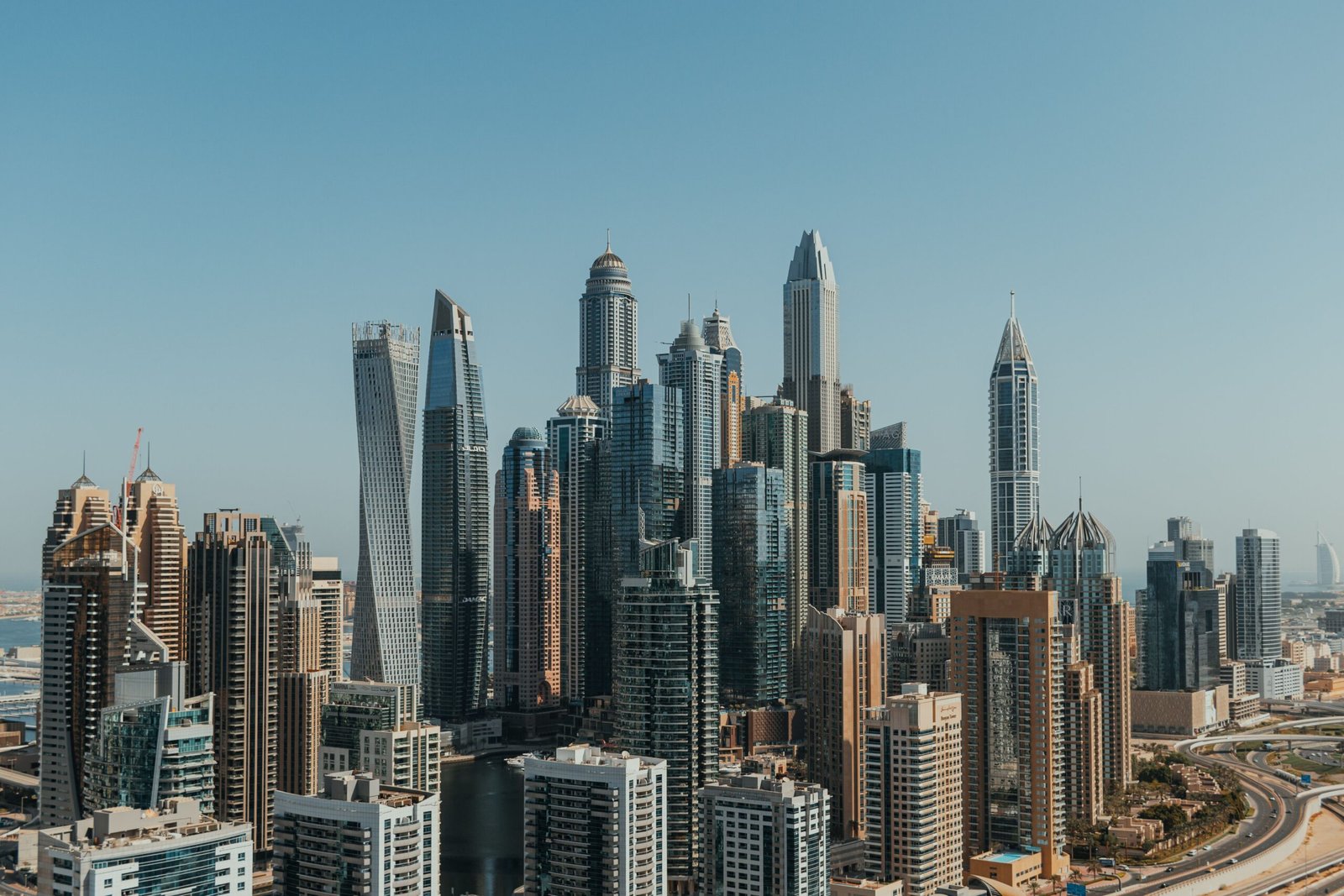 Dubai Marina skyline featuring modern high-rise residential and commercial towers under a clear blue sky.