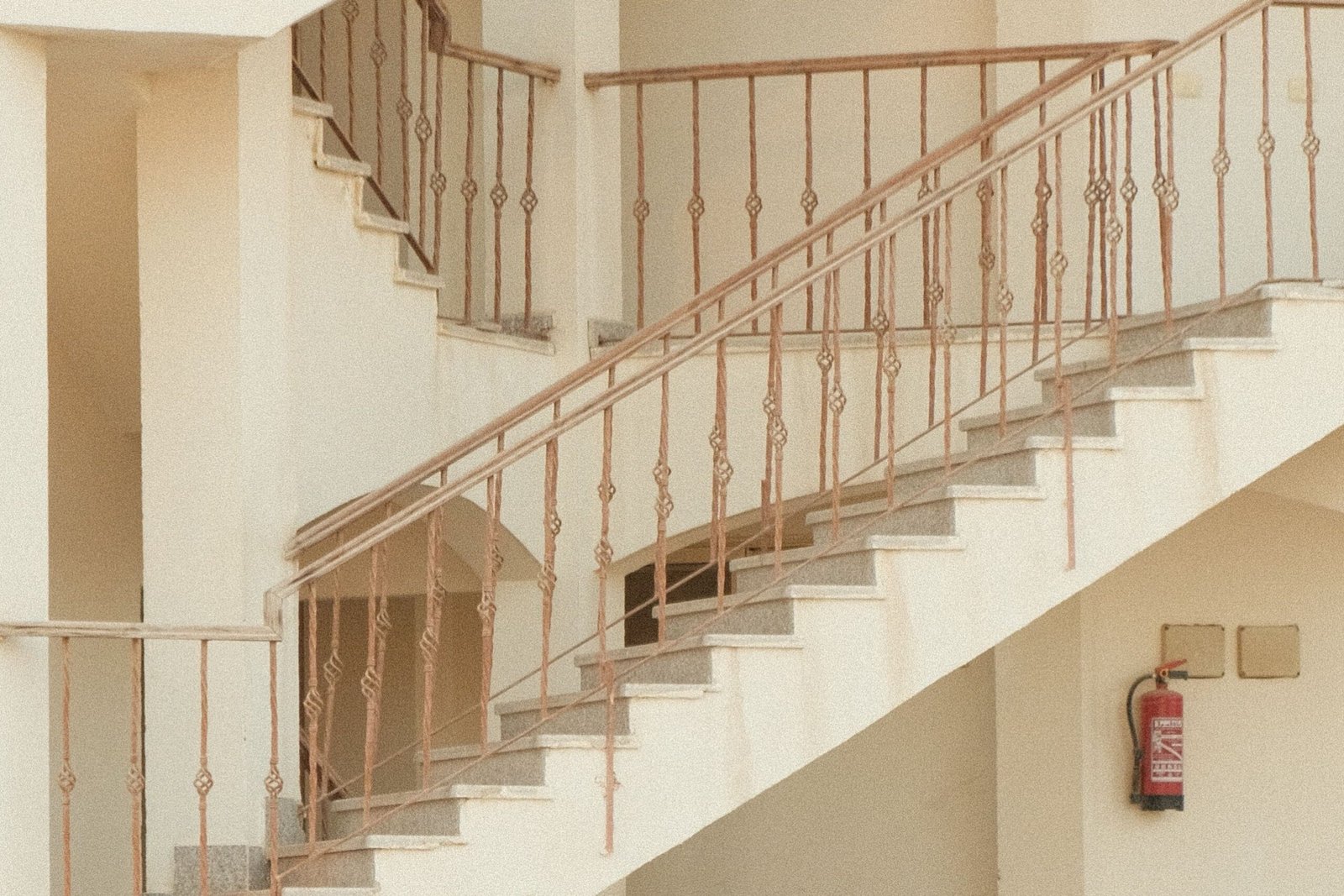 Interior staircases and corridors in a multi-storey staff accommodation building with visible fire extinguishers.