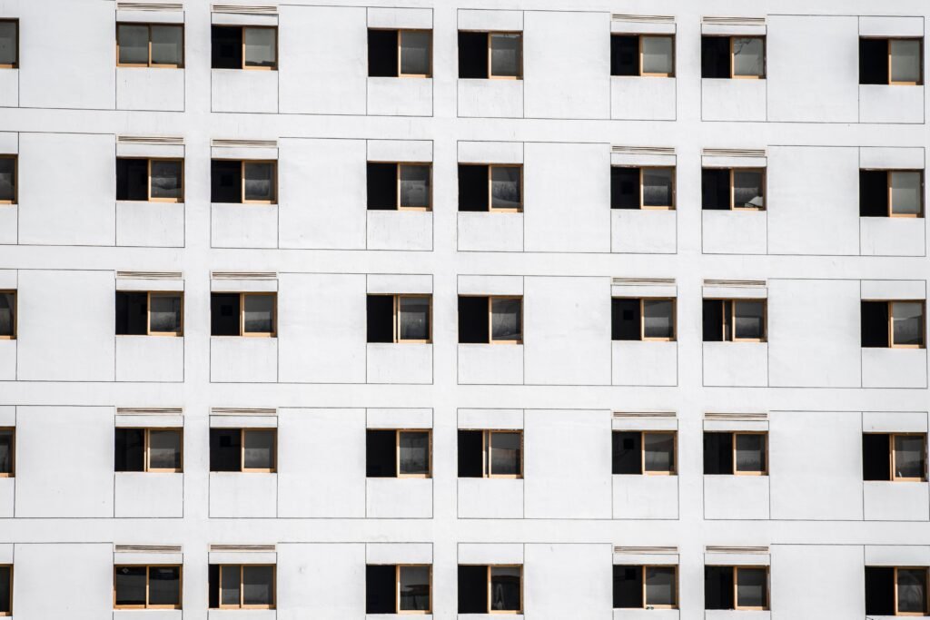 Close-up of a modern apartment building facade with uniform windows in Dubai, UAE.