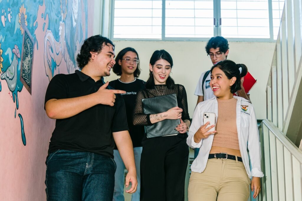 Group of diverse university students engaged in conversation on campus stairs in Culiacán